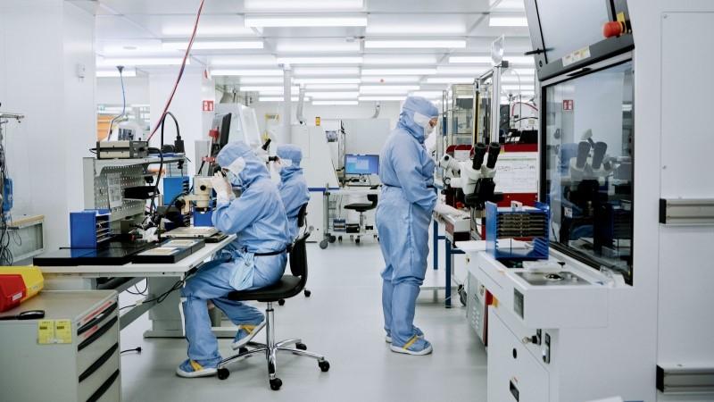 Employees in protective gear working in Vaisala cleanroom