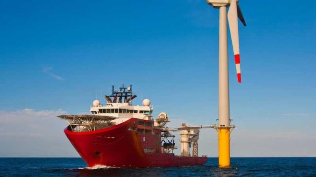 Ship next to offshore wind turbine