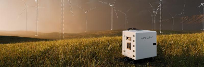 Windcube on field in front of windmills